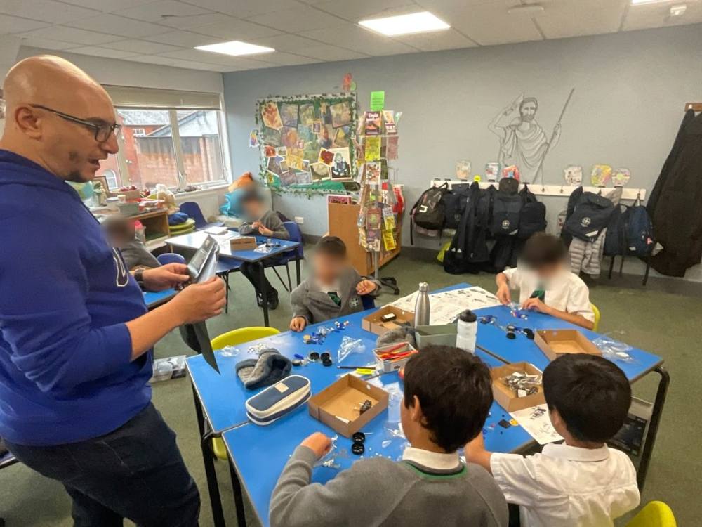 Adaptix instructor guiding pupils as they build race cars