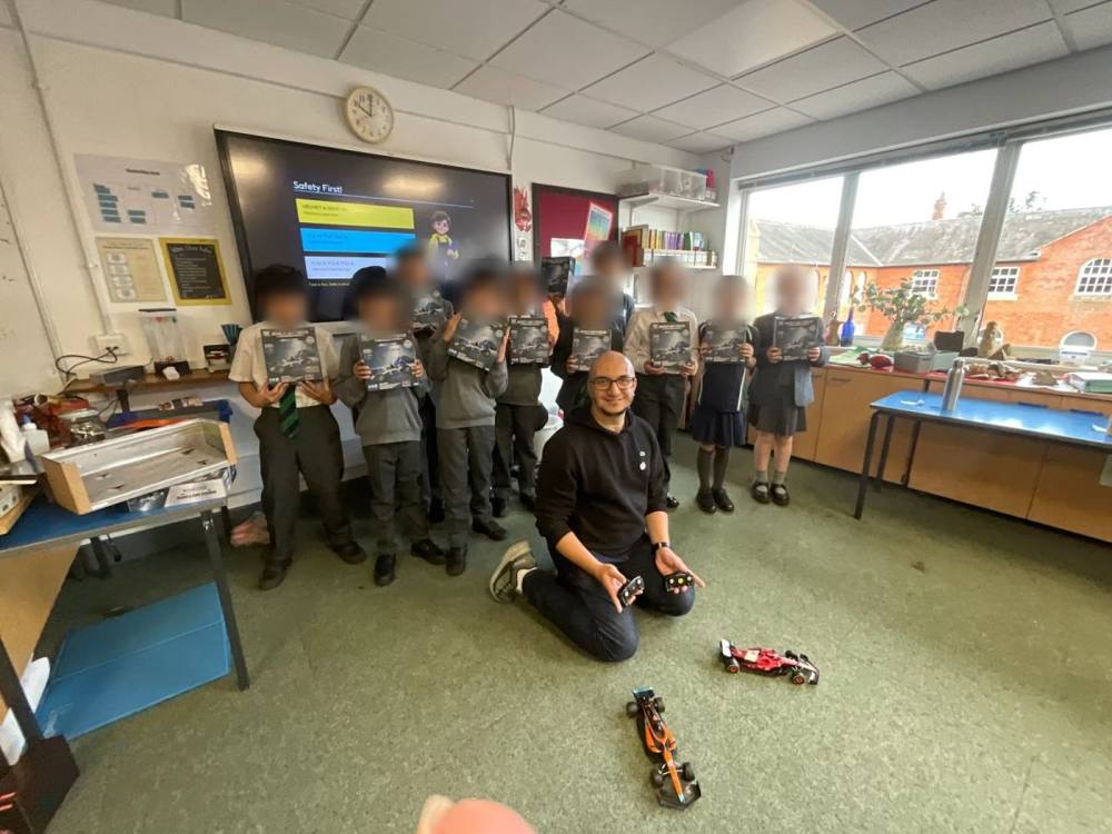 Pupils holding their race-car kits with an Adaptix instructor
